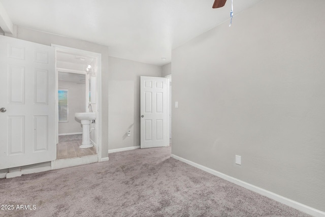 unfurnished bedroom with ensuite bathroom, ceiling fan, and carpet