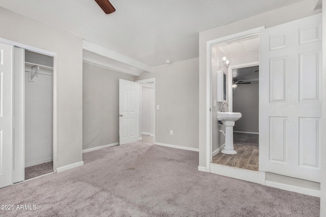 unfurnished bedroom with light carpet, connected bathroom, and ceiling fan