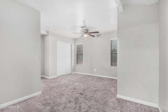 spare room with ceiling fan and light carpet