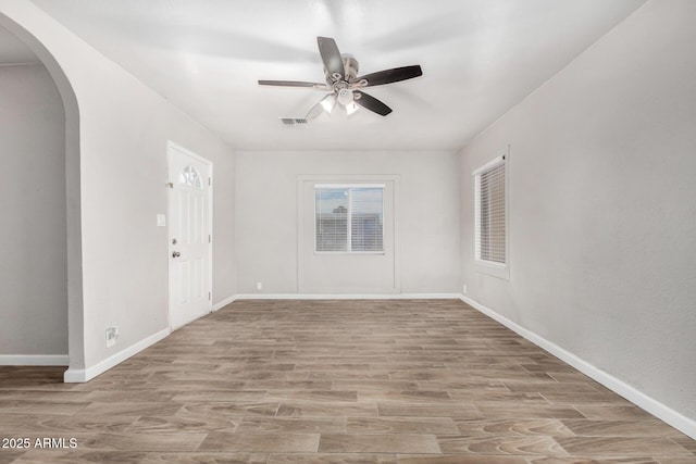 empty room with ceiling fan and light hardwood / wood-style floors