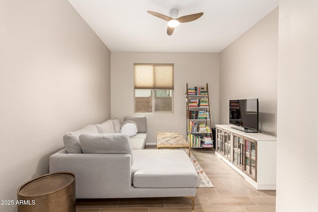 sitting room featuring wood finish floors, baseboards, and a ceiling fan