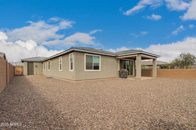 rear view of property with a patio area, a fenced backyard, and stucco siding