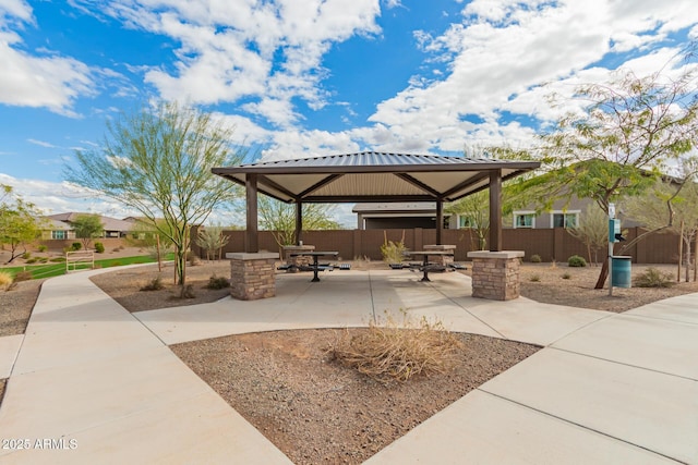 view of community with a gazebo, outdoor dining area, a fenced backyard, and a patio area