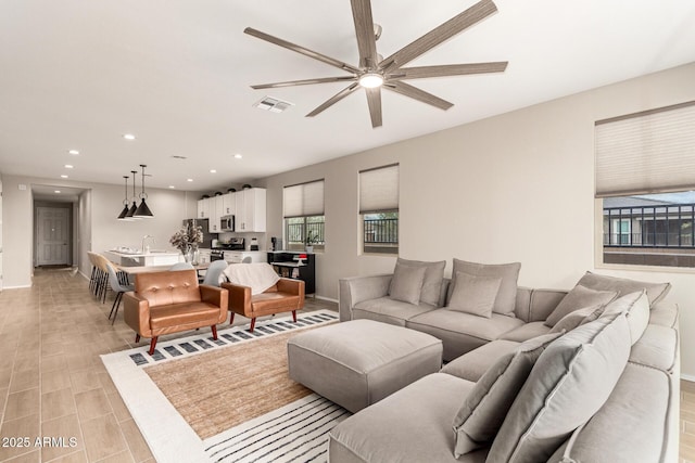 living room featuring visible vents, a ceiling fan, recessed lighting, light wood-style floors, and baseboards