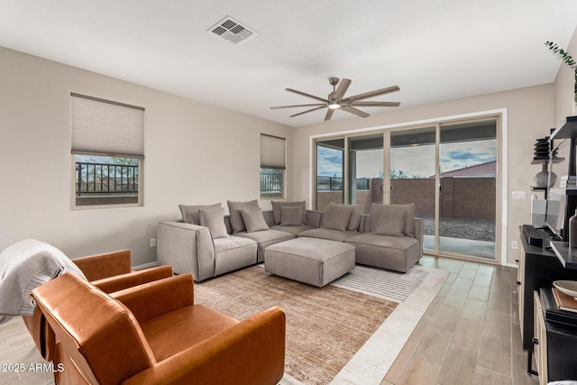 living area featuring visible vents and ceiling fan