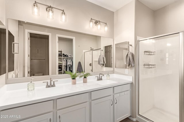 bathroom with a shower stall, toilet, double vanity, and a sink