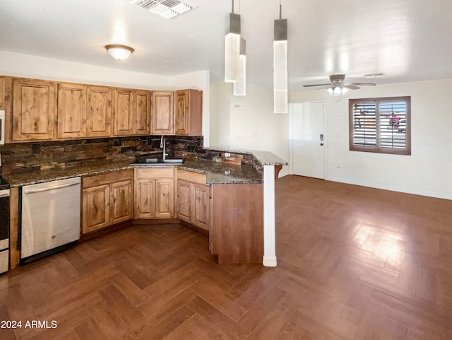 kitchen with sink, kitchen peninsula, decorative light fixtures, dishwasher, and dark stone countertops