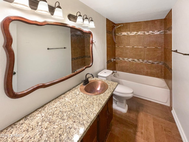 full bathroom with vanity, tiled shower / bath combo, and toilet