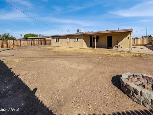 rear view of property with a patio and an outdoor fire pit