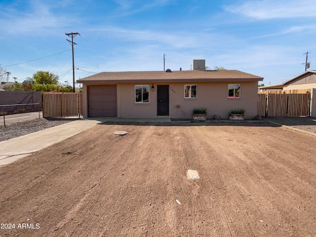 ranch-style home with central air condition unit and a garage