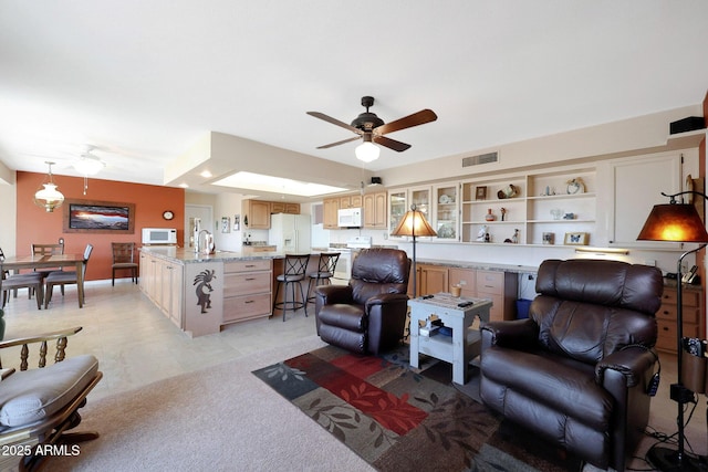 living room featuring ceiling fan and built in shelves