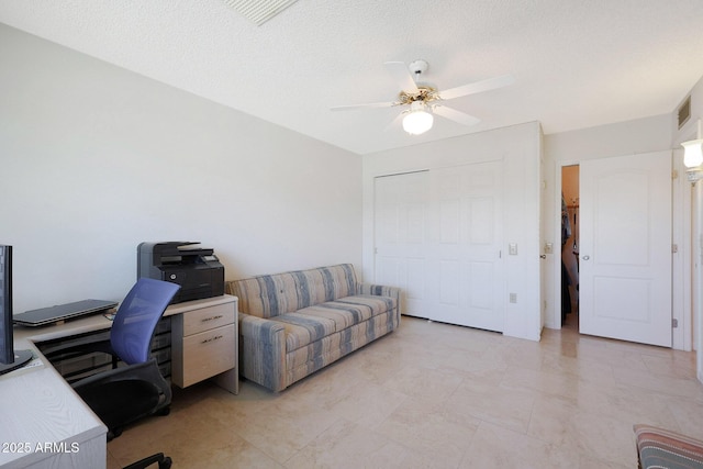 home office with ceiling fan and a textured ceiling