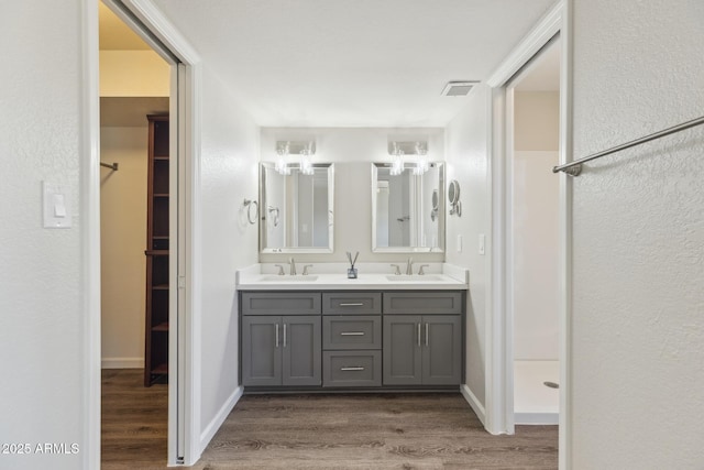 1452 E Gary St, Mesa, AZ 85203 - bathroom featuring wood finished floors, double vanity, and a walk in closet