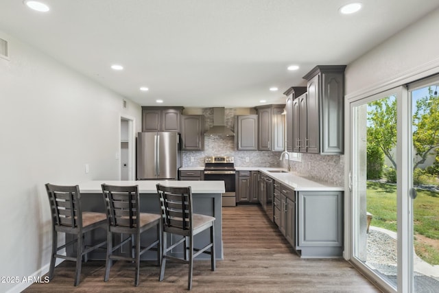 1452 E Gary St, Mesa, AZ 85203 - kitchen featuring appliances with stainless steel finishes, wall chimney exhaust hood, gray cabinets, a kitchen bar, and tasteful backsplash