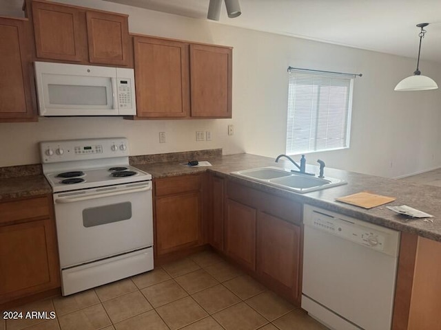 kitchen featuring sink, kitchen peninsula, light tile patterned floors, hanging light fixtures, and white appliances