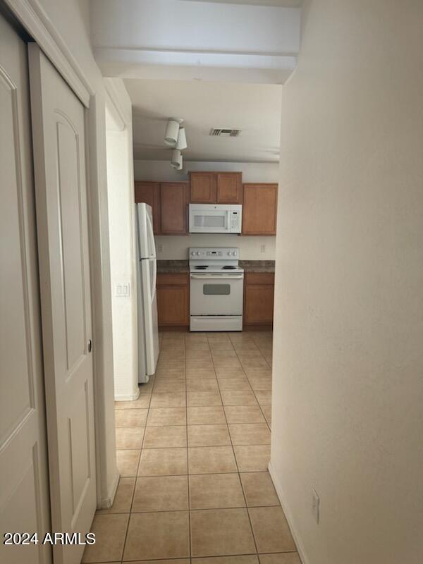 kitchen featuring light tile patterned floors and white appliances