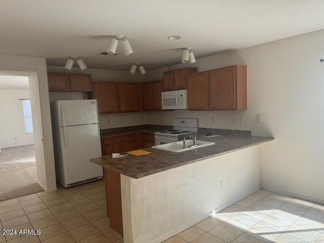 kitchen featuring kitchen peninsula, light tile patterned floors, and white appliances