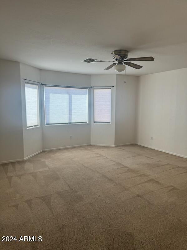 unfurnished room with light carpet and ceiling fan