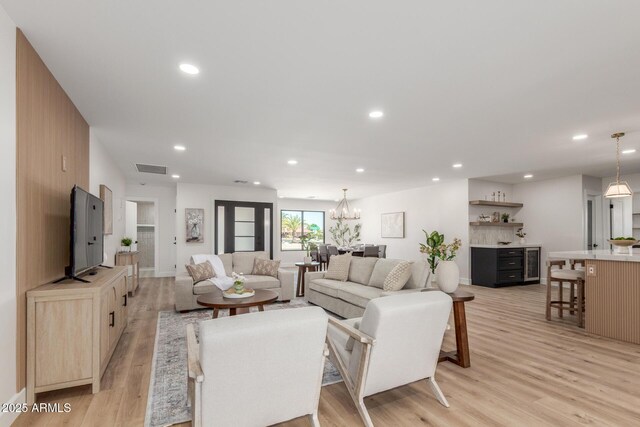 living area with a notable chandelier, light wood-style floors, visible vents, and recessed lighting