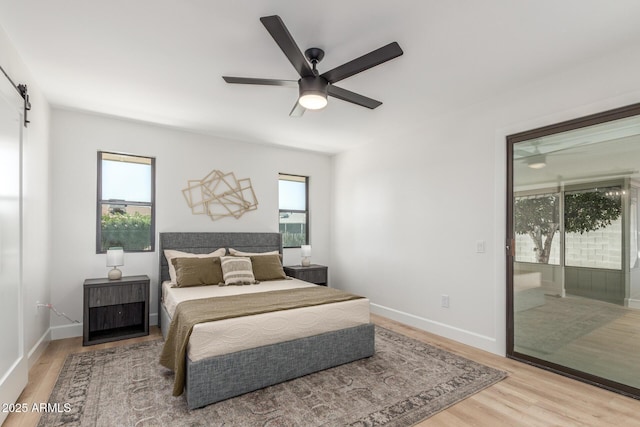 bedroom featuring light wood-style flooring, access to exterior, and multiple windows