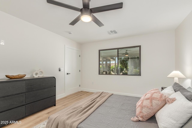 bedroom featuring baseboards, a ceiling fan, wood finished floors, and visible vents