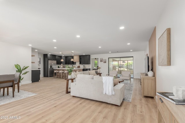 living area featuring recessed lighting, light wood-type flooring, and baseboards