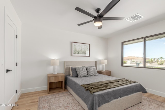 bedroom featuring ceiling fan, baseboards, light wood-style floors, and visible vents