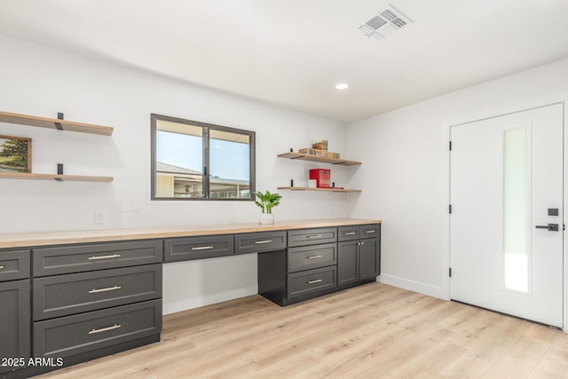 unfurnished office with built in study area, recessed lighting, visible vents, and light wood-type flooring