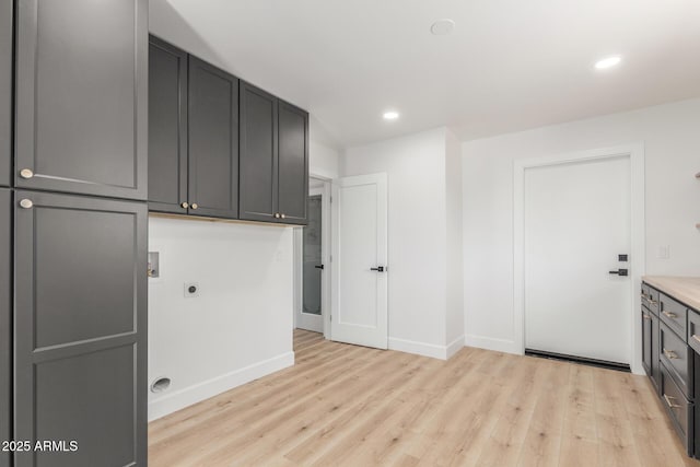 laundry area with hookup for an electric dryer, baseboards, light wood-style floors, washer hookup, and cabinet space
