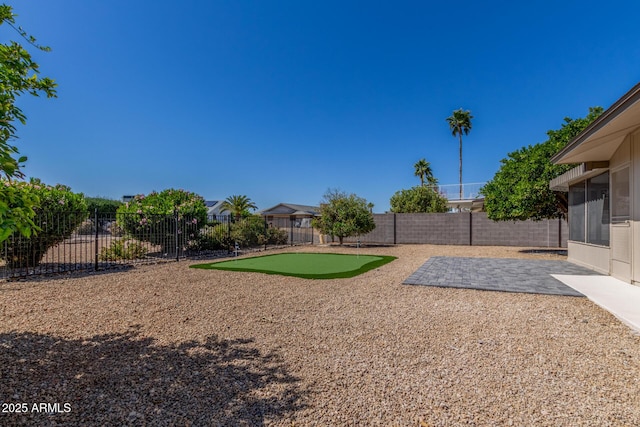 view of yard with a fenced backyard, a sunroom, and a patio