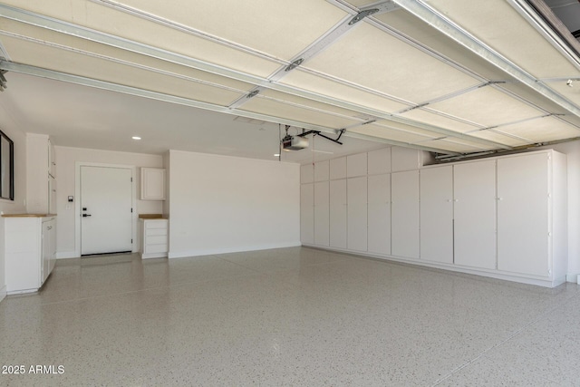 garage featuring baseboards, recessed lighting, and a garage door opener