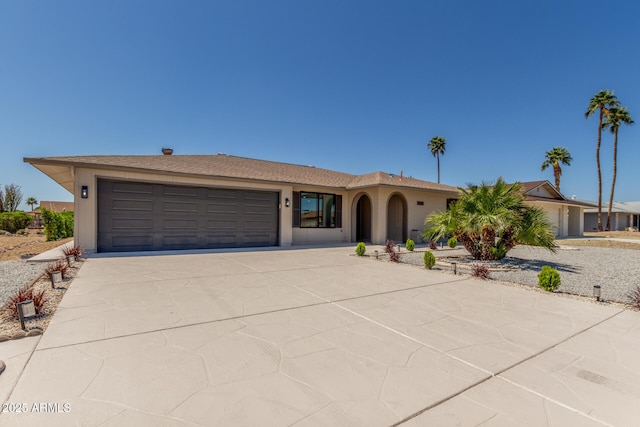 single story home featuring concrete driveway and an attached garage