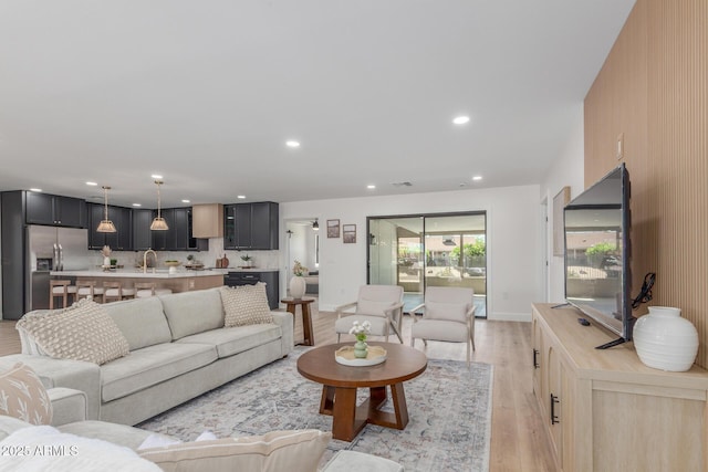 living area featuring recessed lighting, visible vents, and light wood finished floors