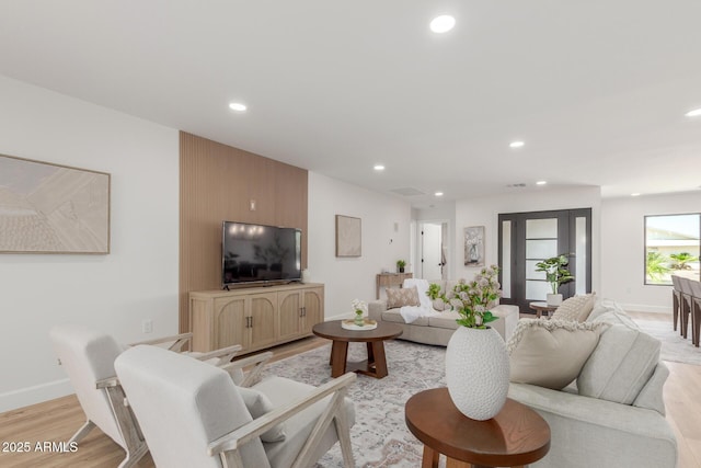 living area featuring recessed lighting, light wood-style flooring, and baseboards