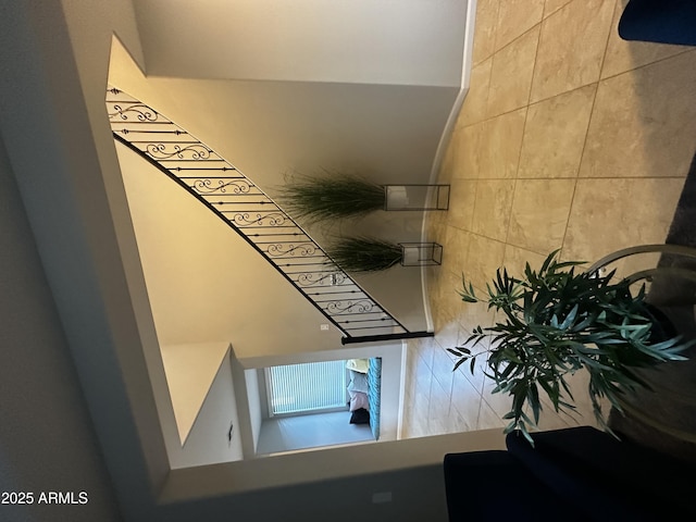 stairway featuring tile walls