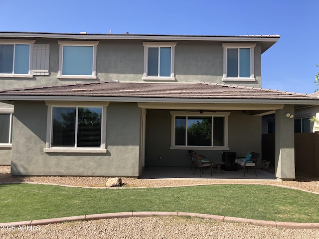 back of property with a patio area and a yard