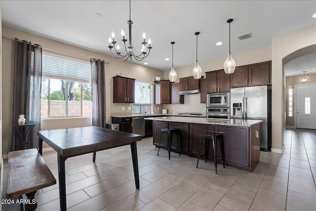 kitchen with pendant lighting, dark brown cabinetry, a center island, and stainless steel appliances