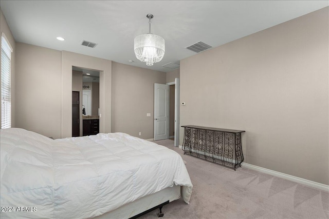 carpeted bedroom featuring an inviting chandelier and ensuite bathroom