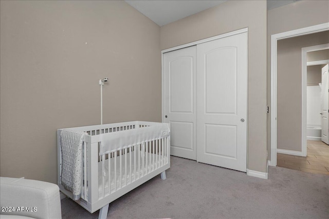 carpeted bedroom with a nursery area and a closet