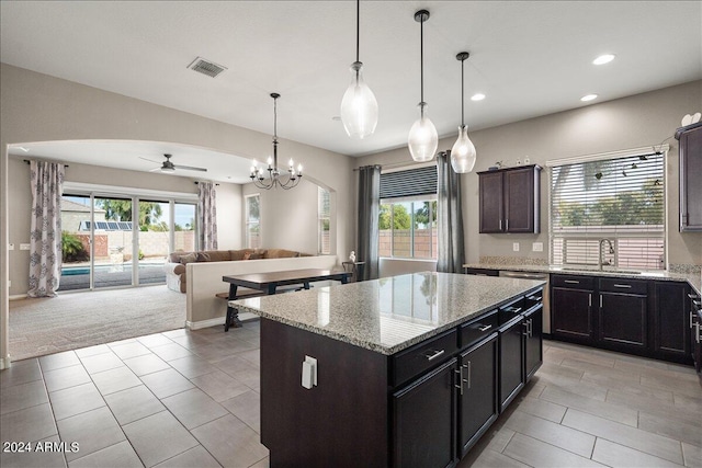 kitchen with pendant lighting, sink, a healthy amount of sunlight, and a center island