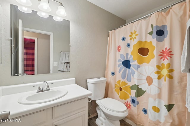 bathroom with a shower with shower curtain, vanity, and toilet