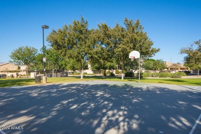 view of sport court with a lawn