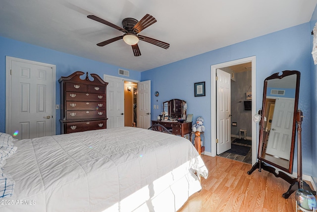 bedroom with ceiling fan, ensuite bathroom, and light hardwood / wood-style flooring