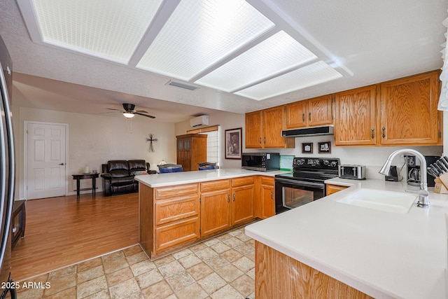 kitchen featuring sink, ceiling fan, kitchen peninsula, black / electric stove, and an AC wall unit