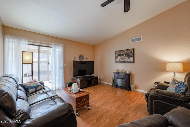 living room featuring vaulted ceiling, ceiling fan, and light wood-type flooring