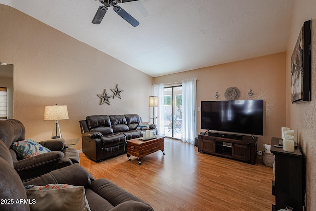 living room featuring lofted ceiling, ceiling fan, and light wood-type flooring