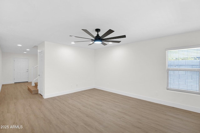 empty room with recessed lighting, light wood-style floors, a ceiling fan, and baseboards