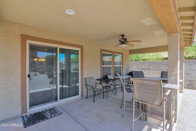 view of patio featuring fence, a ceiling fan, and outdoor dining area