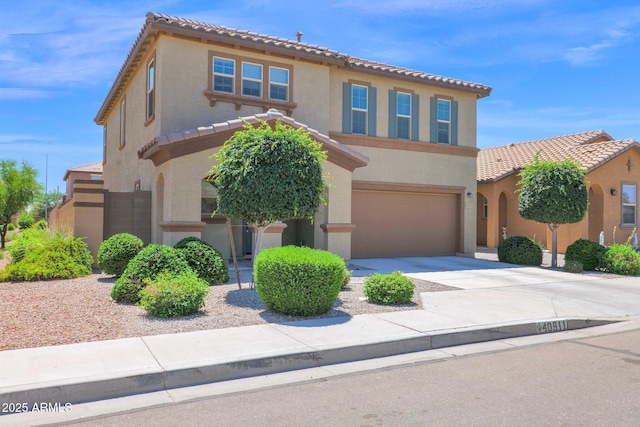 mediterranean / spanish-style home with an attached garage, a tile roof, driveway, and stucco siding