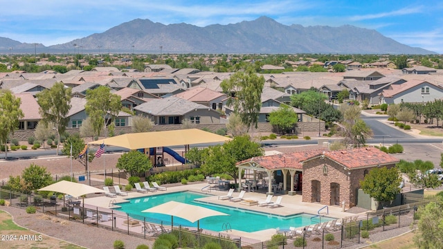 pool with fence, a residential view, a mountain view, and a patio